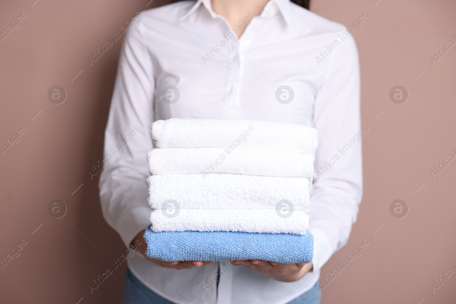 Woman with clean towels on beige background, closeup Photo of Woman with clean towels on beige background, closeup