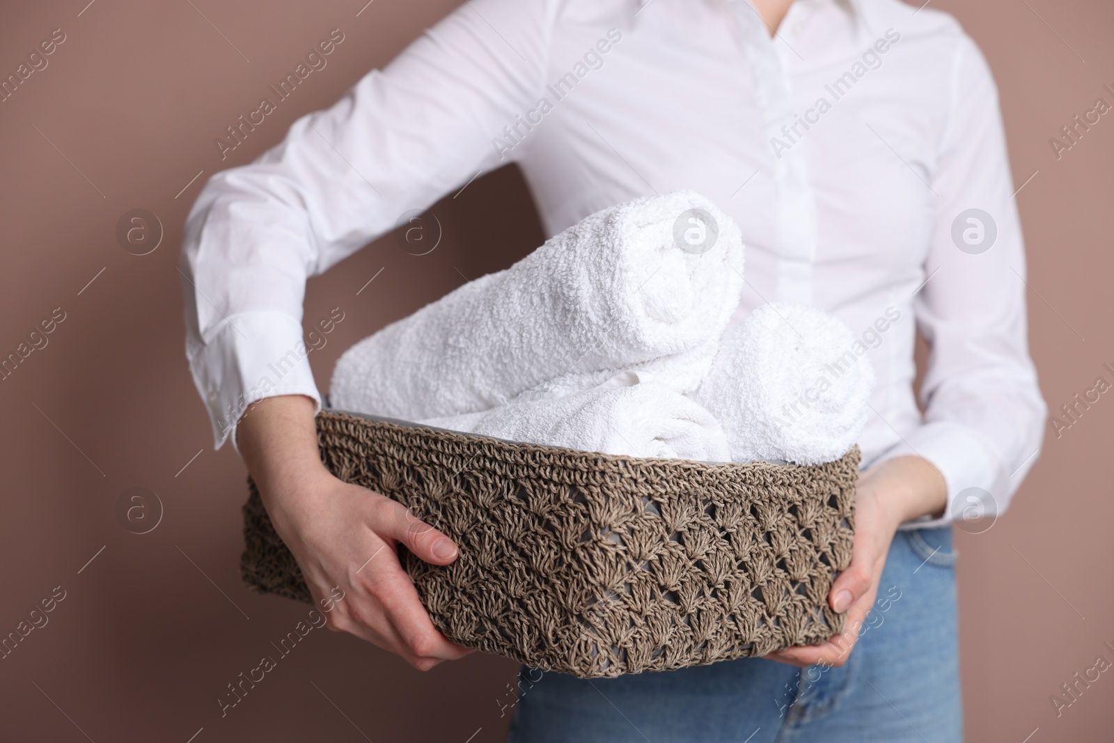 Photo of Woman with clean towels on beige background, closeup