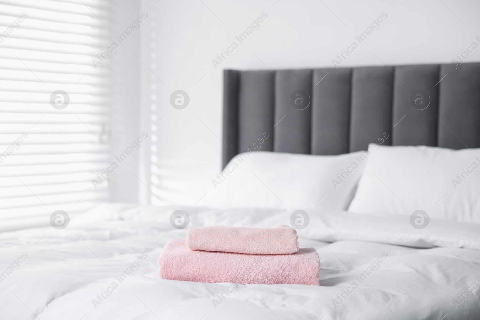 Photo of Clean terry towels on bed at home
