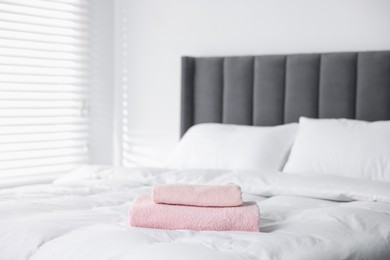 Photo of Clean terry towels on bed at home