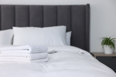 Photo of Clean terry towels on bed at home, space for text