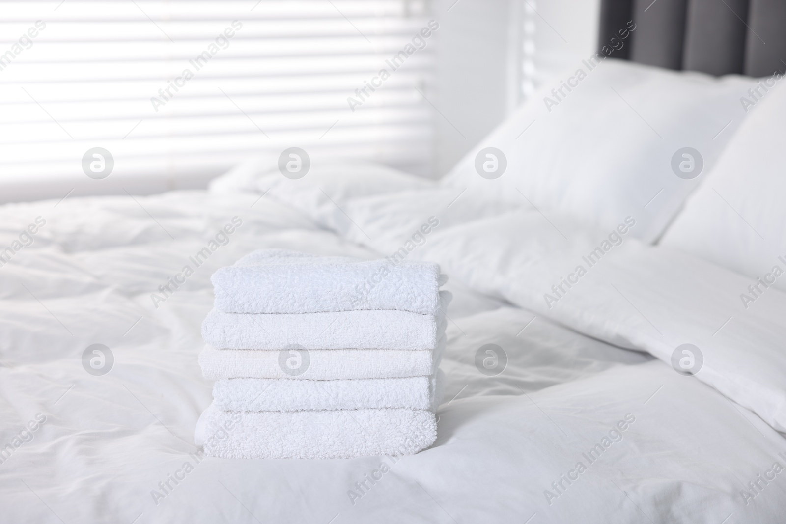 Clean terry towels on bed at home Photo of Clean terry towels on bed at home