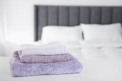 Photo of Clean terry towels on bed at home, closeup. Space for text