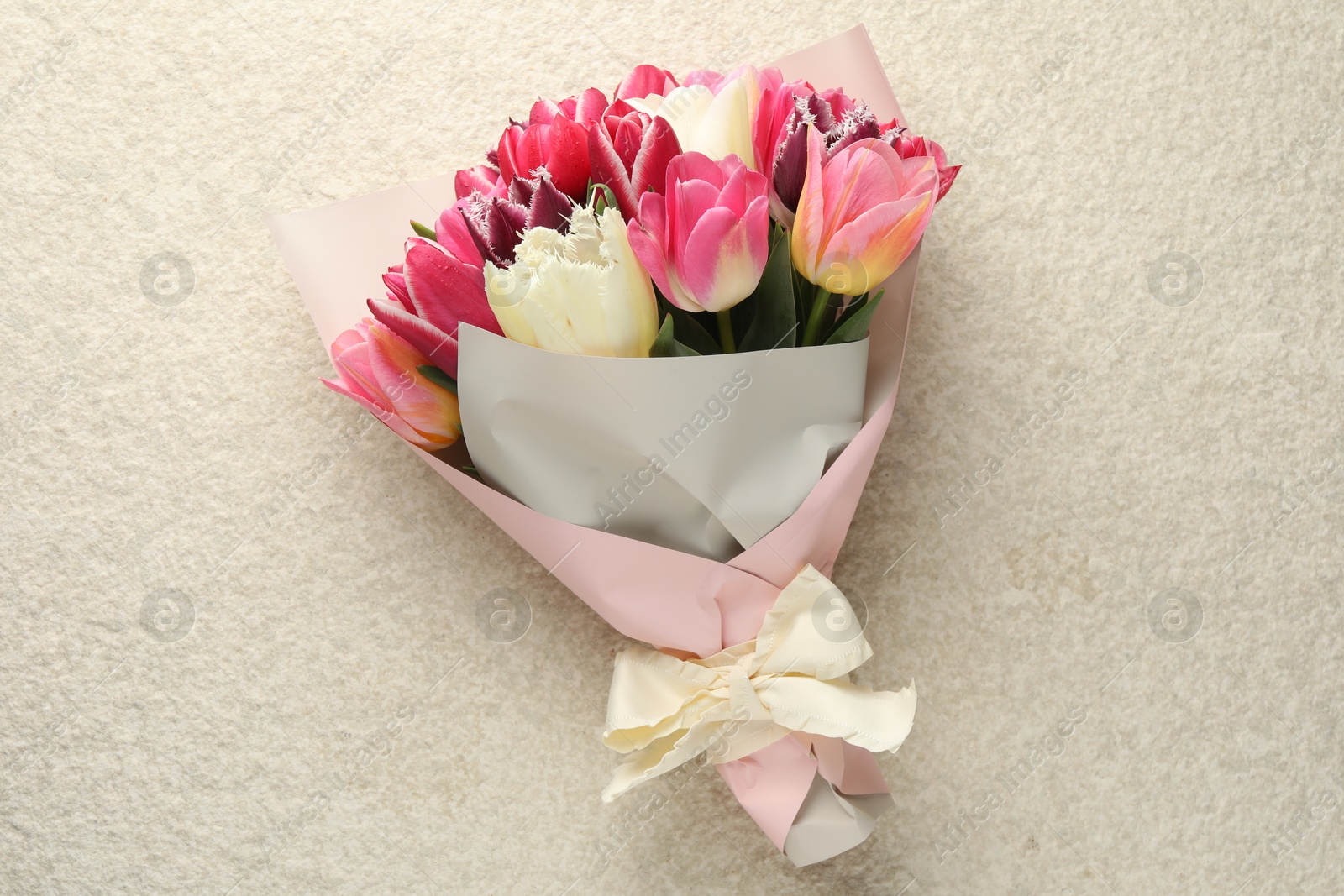 Bouquet of beautiful tulips on white textured table, top view Photo of Bouquet of beautiful tulips on white textured table, top view
