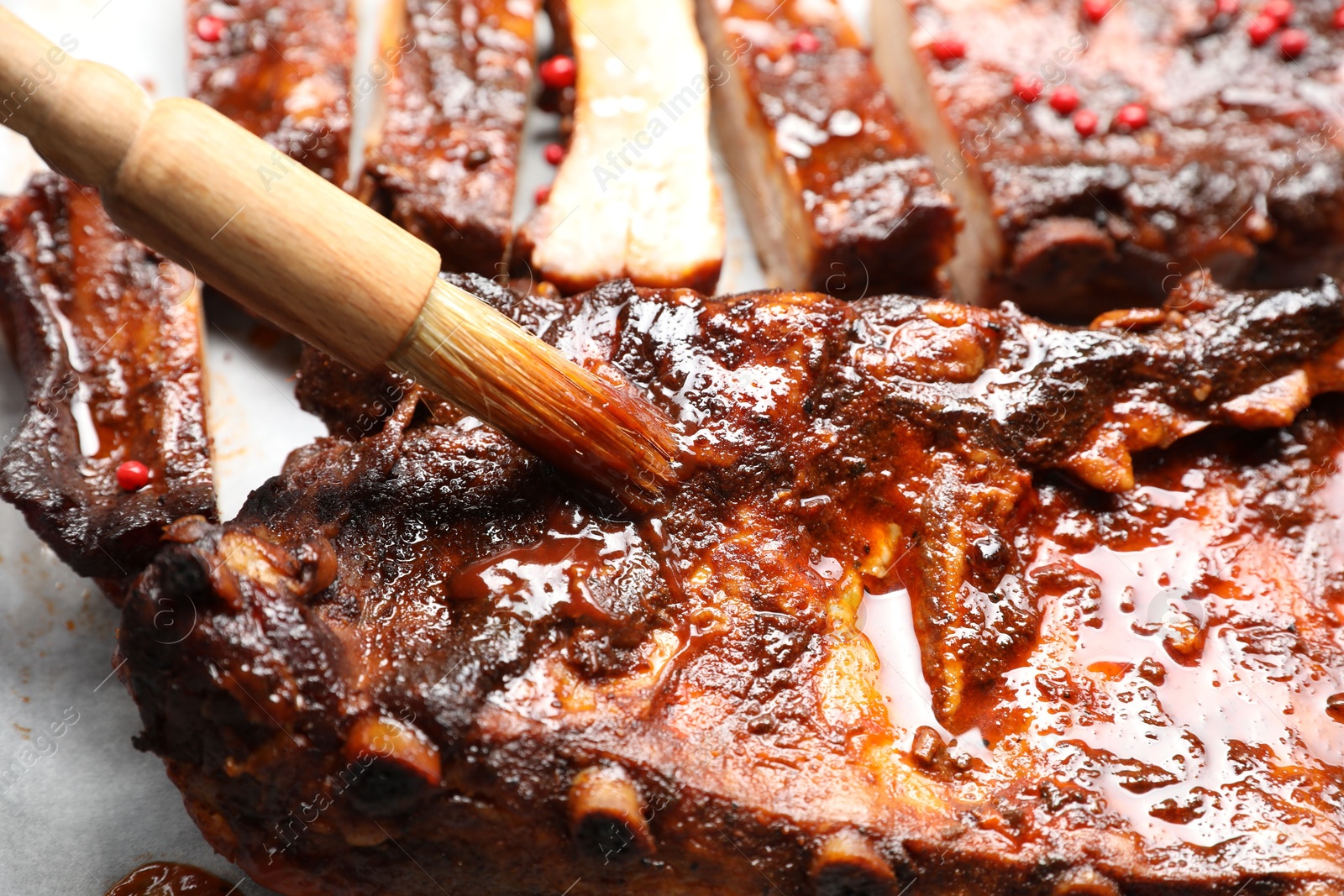 Spreading sauce with brush onto delicious spare ribs, closeup Photo of Spreading sauce with brush onto delicious spare ribs, closeup