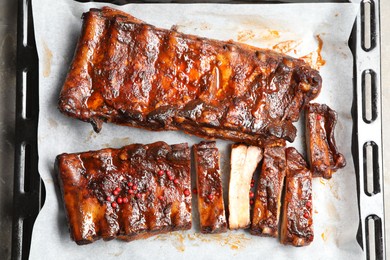 Photo of Delicious spare ribs on grey table, top view