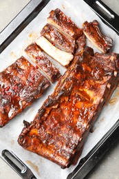 Photo of Delicious spare ribs on grey textured table, top view