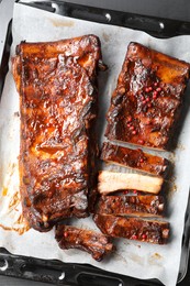 Photo of Delicious spare ribs on grey table, top view