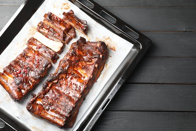 Photo of Delicious spare ribs on grey wooden table, top view