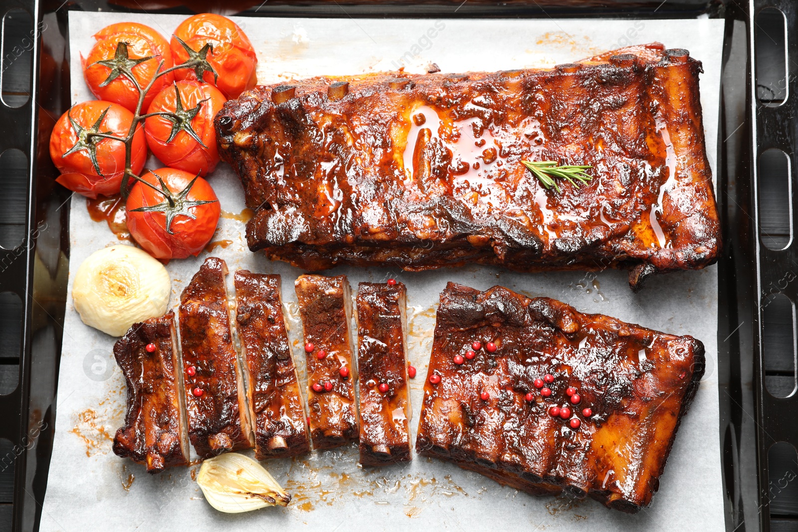 Delicious spare ribs, baked onion and sun dried tomatoes on baking tray, top view Photo of Delicious spare ribs, baked onion and sun dried tomatoes on baking tray, top view