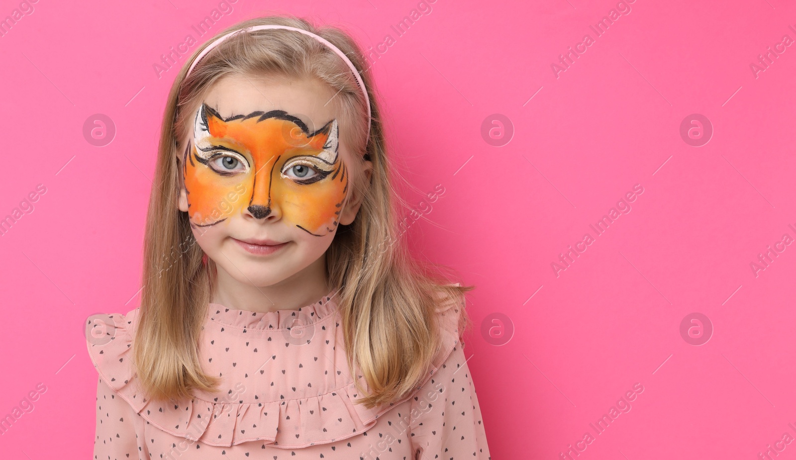 Cute girl with fox face painting on pink background, space for text Photo of Cute girl with fox face painting on pink background, space for text