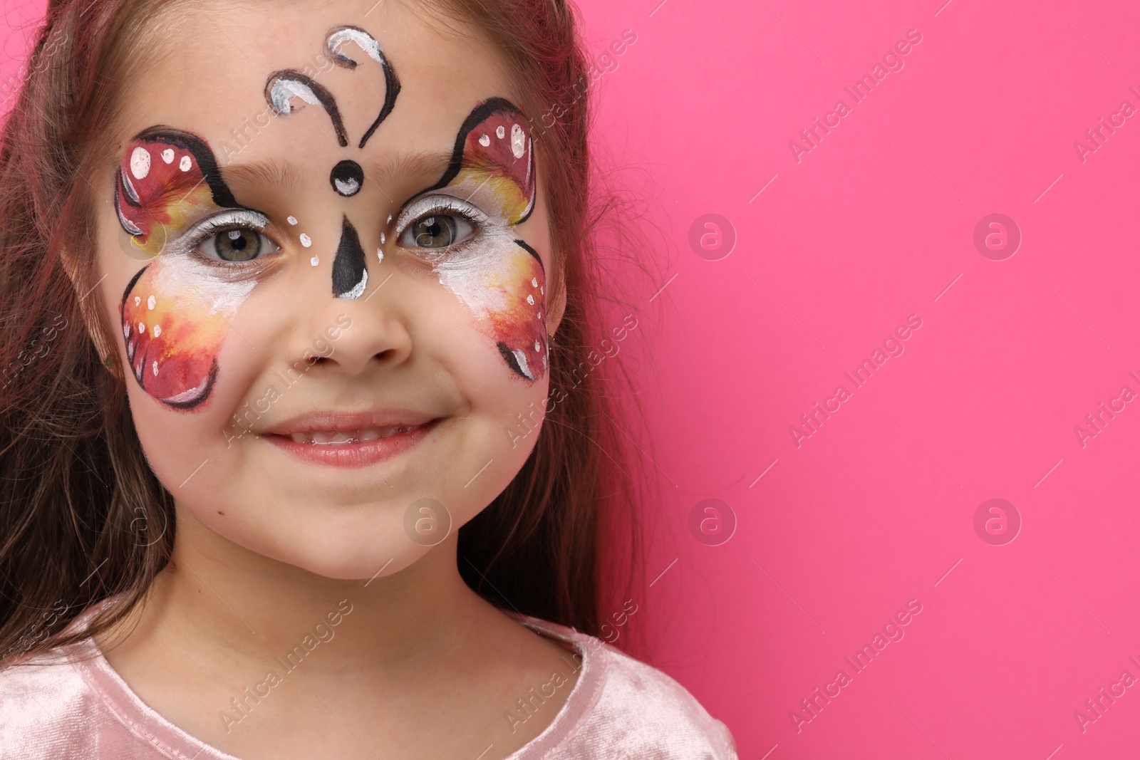 Cute girl with butterfly face painting on pink background, space for text Photo of Cute girl with butterfly face painting on pink background, space for text