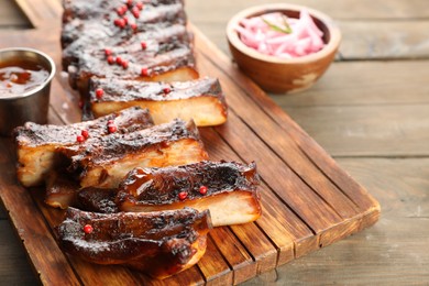 Photo of Delicious spare ribs on wooden table, closeup