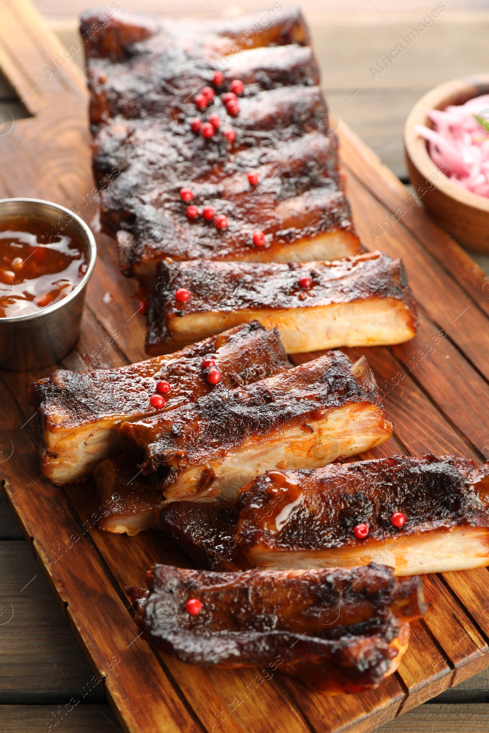 Delicious spare ribs and sauce on wooden table Photo of Delicious spare ribs and sauce on wooden table