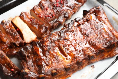 Photo of Delicious spare ribs on baking tray, closeup