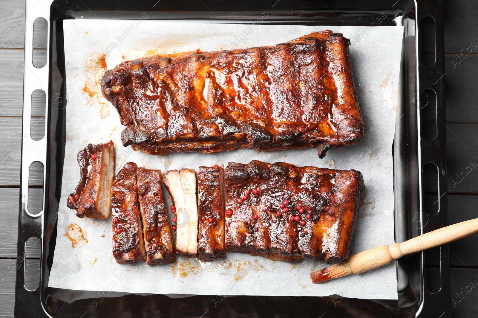 Delicious spare ribs and brush on grey wooden table, top view Photo of Delicious spare ribs and brush on grey wooden table, top view
