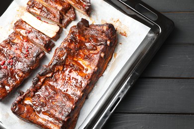 Photo of Delicious spare ribs on grey wooden table, top view