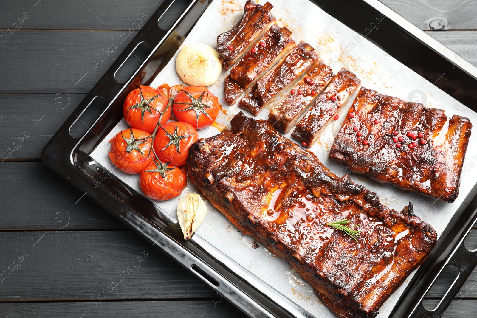 Delicious spare ribs, baked onion and sun dried tomatoes on grey wooden table, top view Photo of Delicious spare ribs, baked onion and sun dried tomatoes on grey wooden table, top view