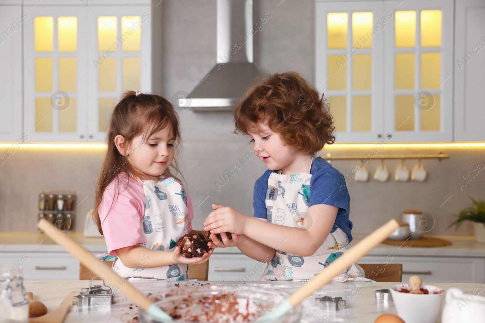 Cooking recipe. Little children making dough for cookies at table in kitchen Photo of Cooking recipe. Little children making dough for cookies at table in kitchen