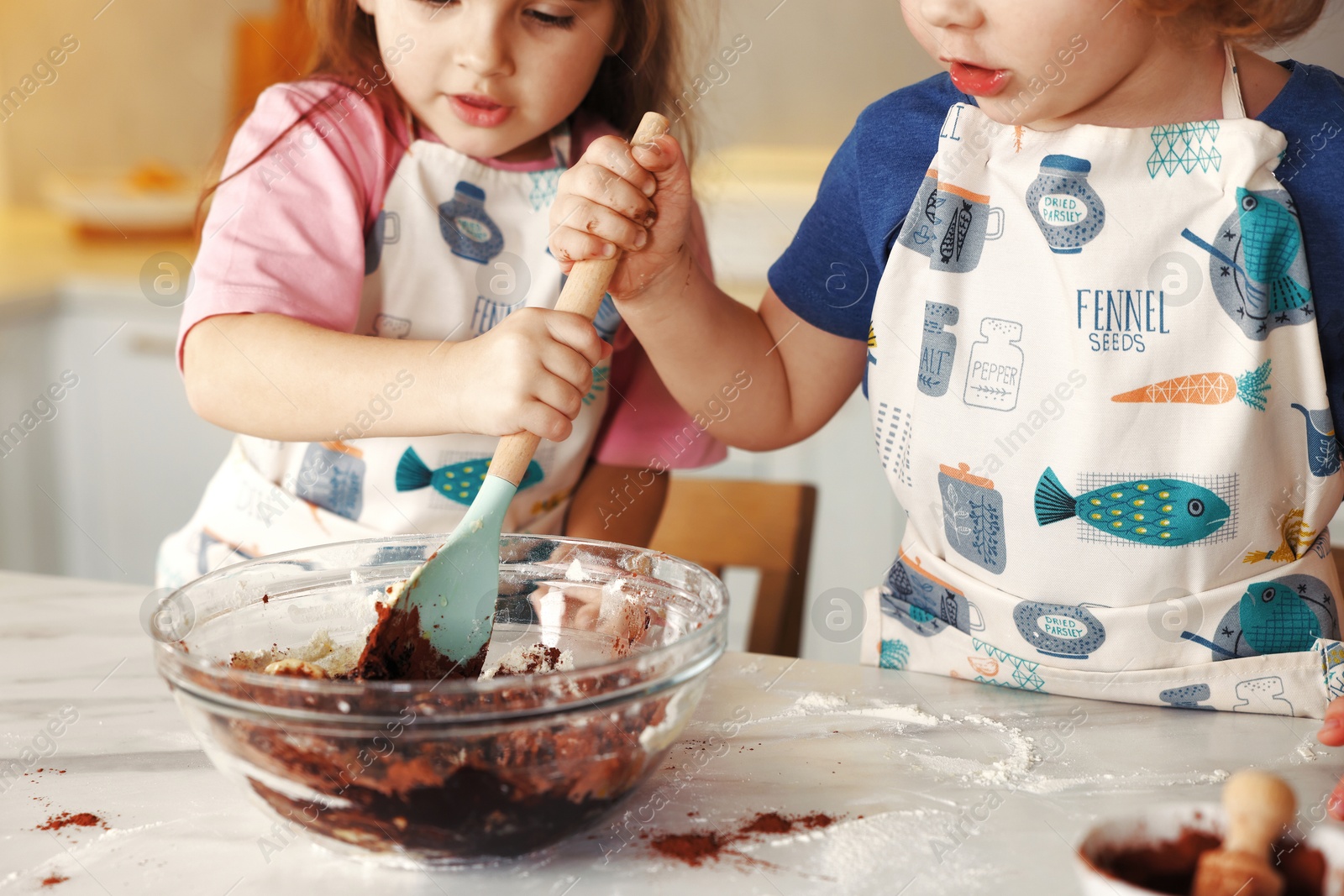 Cooking recipe. Cute children mixing dough for cookies at table in kitchen, closeup Photo of Cooking recipe. Cute children mixing dough for cookies at table in kitchen, closeup
