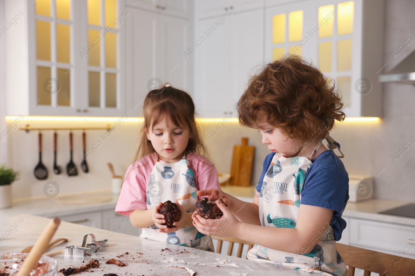 Cooking recipe. Little children making dough for cookies at table in kitchen Photo of Cooking recipe. Little children making dough for cookies at table in kitchen