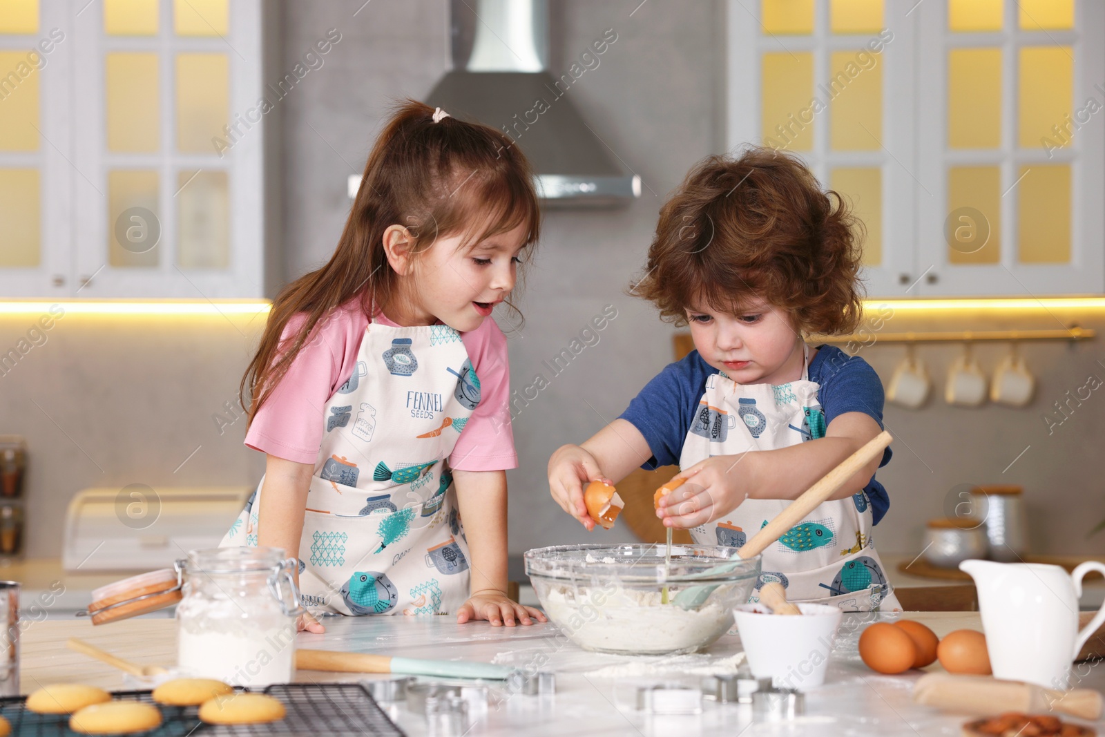 Cooking recipe. Cute children making dough for cookies at table in kitchen Photo of Cooking recipe. Cute children making dough for cookies at table in kitchen