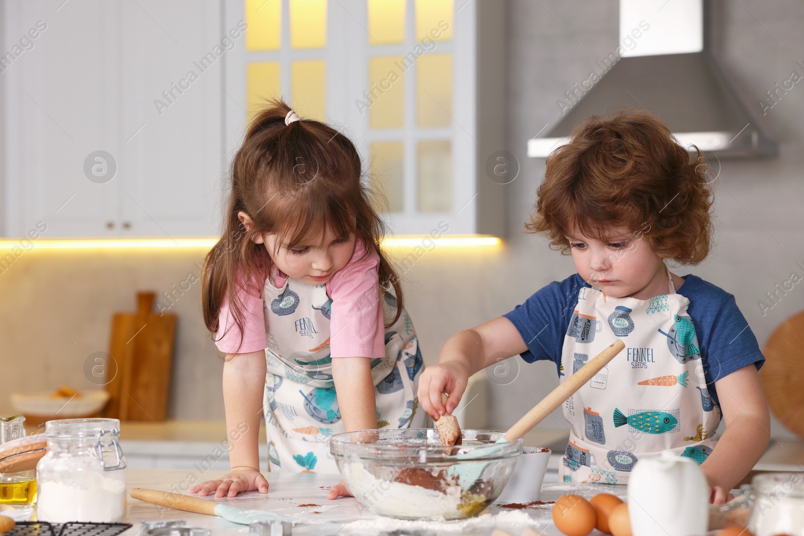 Cooking recipe. Cute children making dough for cookies at table in kitchen Photo of Cooking recipe. Cute children making dough for cookies at table in kitchen