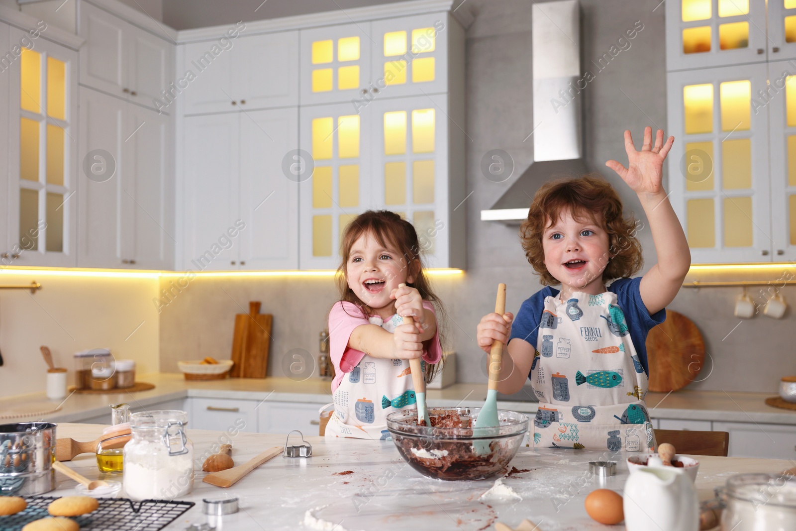 Cooking recipe. Cute children mixing dough for cookies at table in kitchen Photo of Cooking recipe. Cute children mixing dough for cookies at table in kitchen