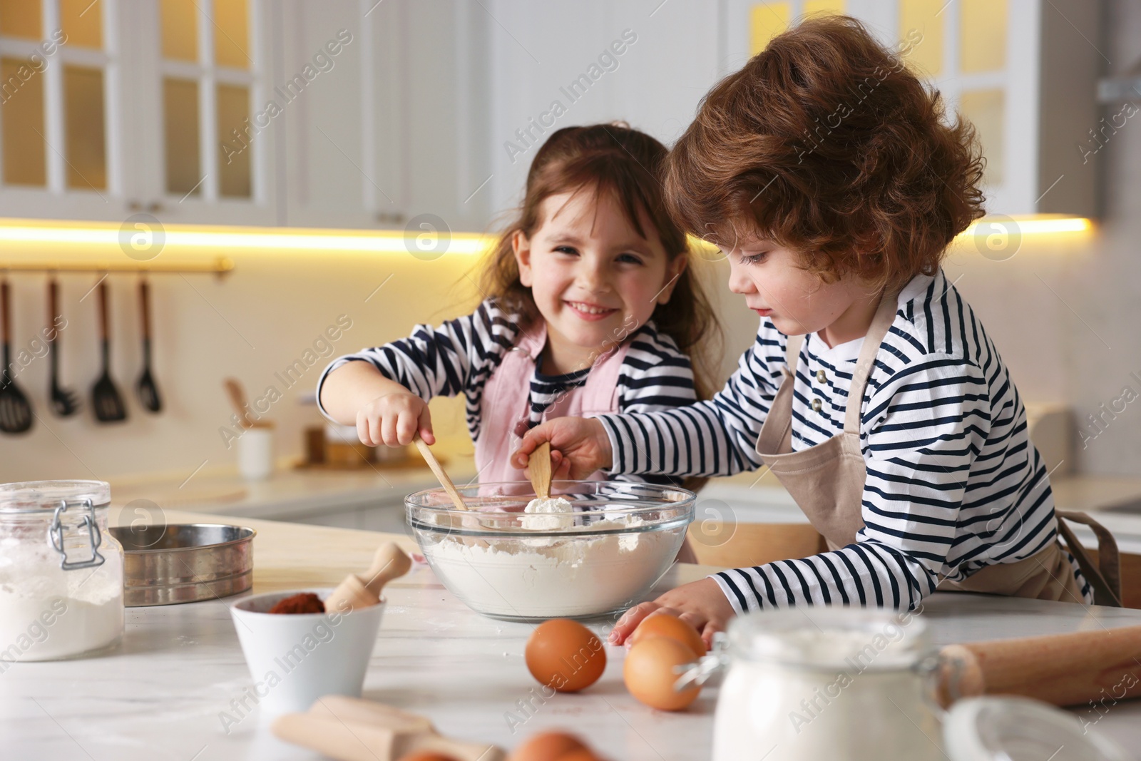Cooking recipe. Cute children making dough for cookies at table in kitchen Photo of Cooking recipe. Cute children making dough for cookies at table in kitchen