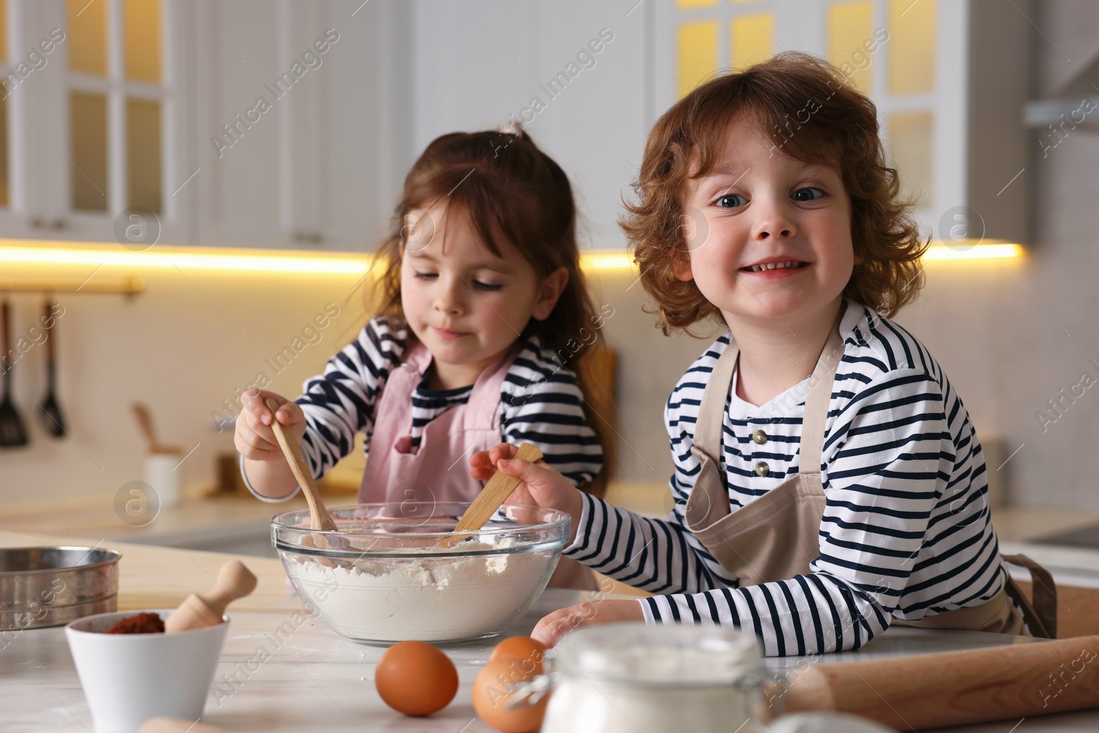 Cooking recipe. Cute children making dough for cookies at table in kitchen Photo of Cooking recipe. Cute children making dough for cookies at table in kitchen