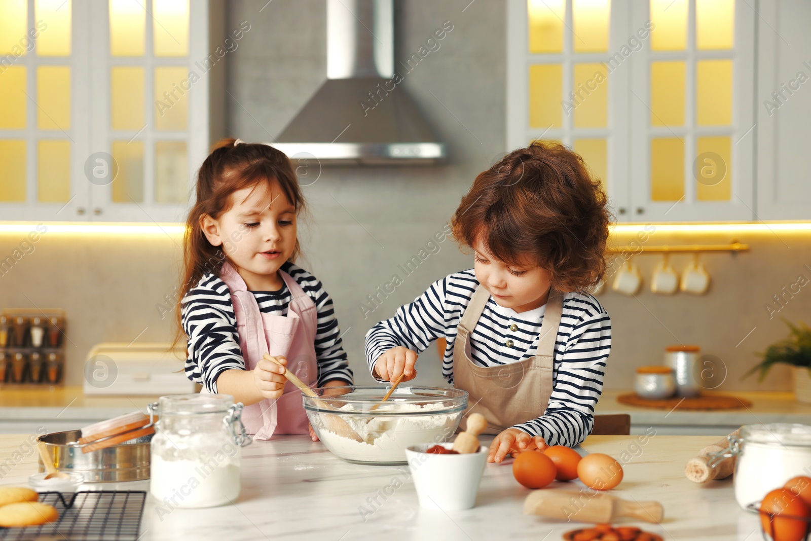 Cooking recipe. Cute children making dough for cookies at table in kitchen Photo of Cooking recipe. Cute children making dough for cookies at table in kitchen