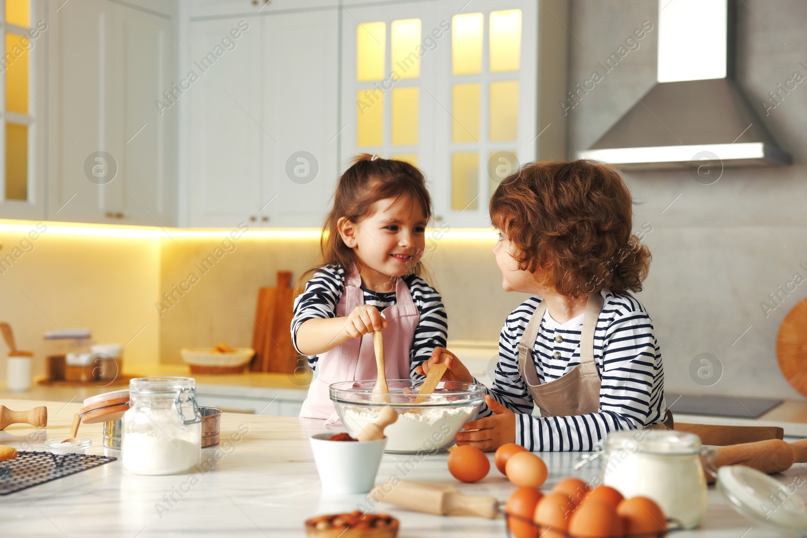 Cooking recipe. Cute children making dough for cookies at table in kitchen Photo of Cooking recipe. Cute children making dough for cookies at table in kitchen