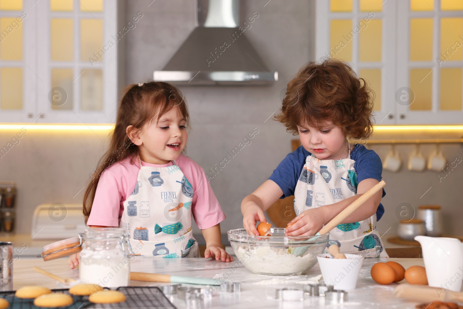 Cooking recipe. Cute children making dough for cookies at table in kitchen Photo of Cooking recipe. Cute children making dough for cookies at table in kitchen