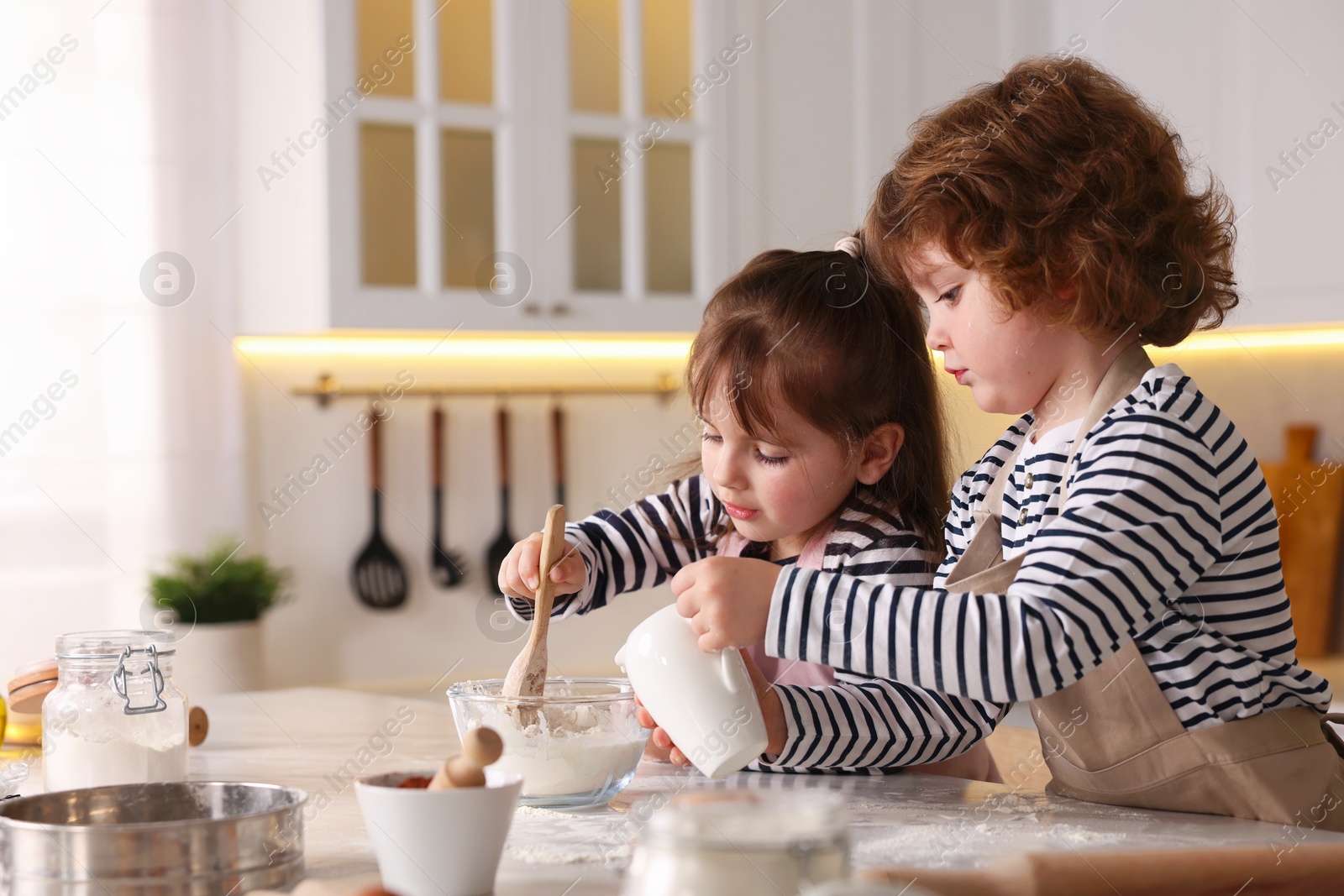 Cooking recipe. Cute children making dough for cookies at table in kitchen. Space for text Photo of Cooking recipe. Cute children making dough for cookies at table in kitchen. Space for text