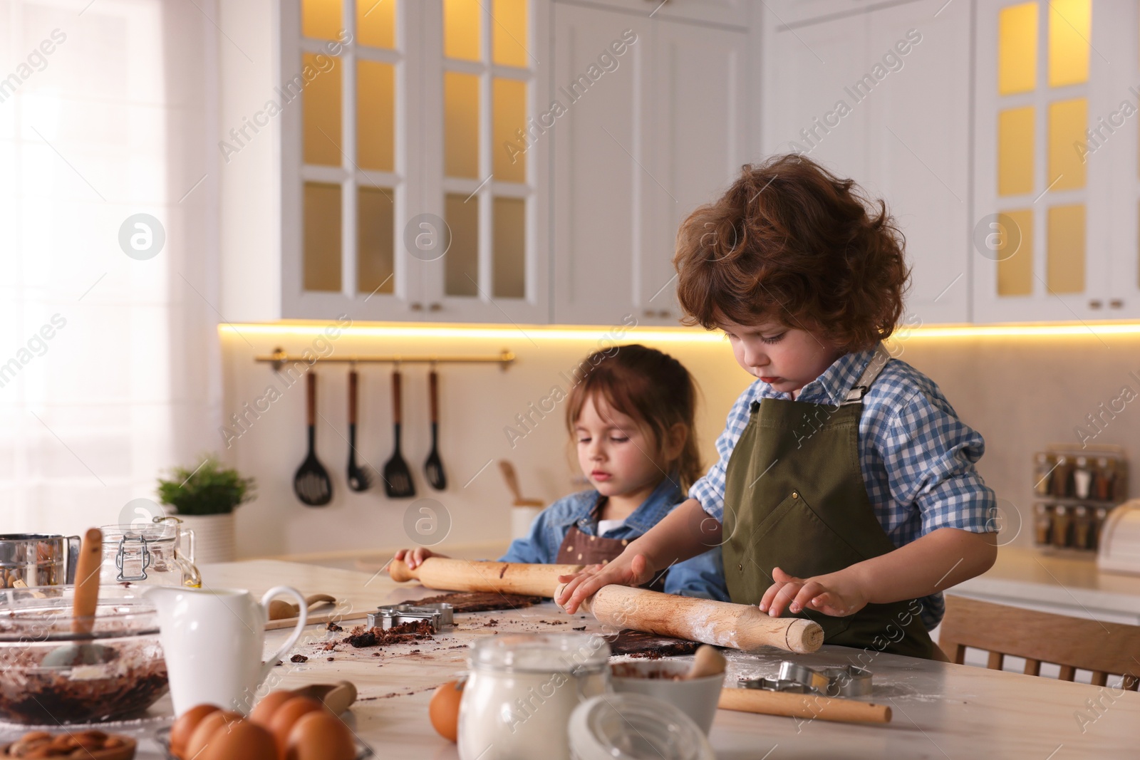 Cooking recipe. Little children making cookies at table in kitchen. Space for text Photo of Cooking recipe. Little children making cookies at table in kitchen. Space for text