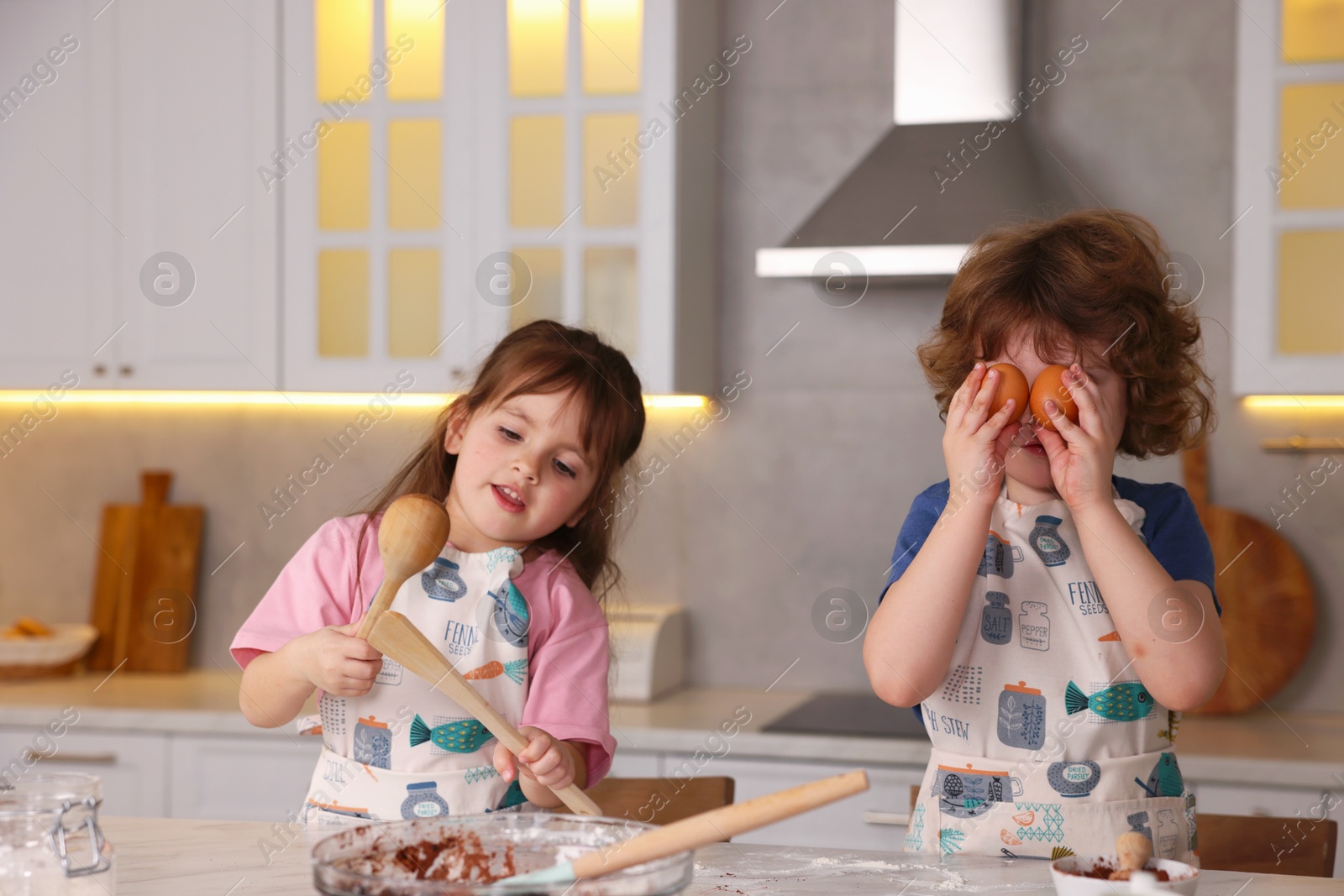 Little children having fun while cooking in kitchen Photo of Little children having fun while cooking in kitchen