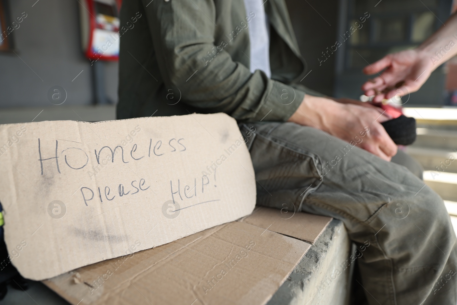 Woman giving money to poor man outdoors, focus on sign Homeless please help Photo of Woman giving money to poor man outdoors, focus on sign Homeless please help
