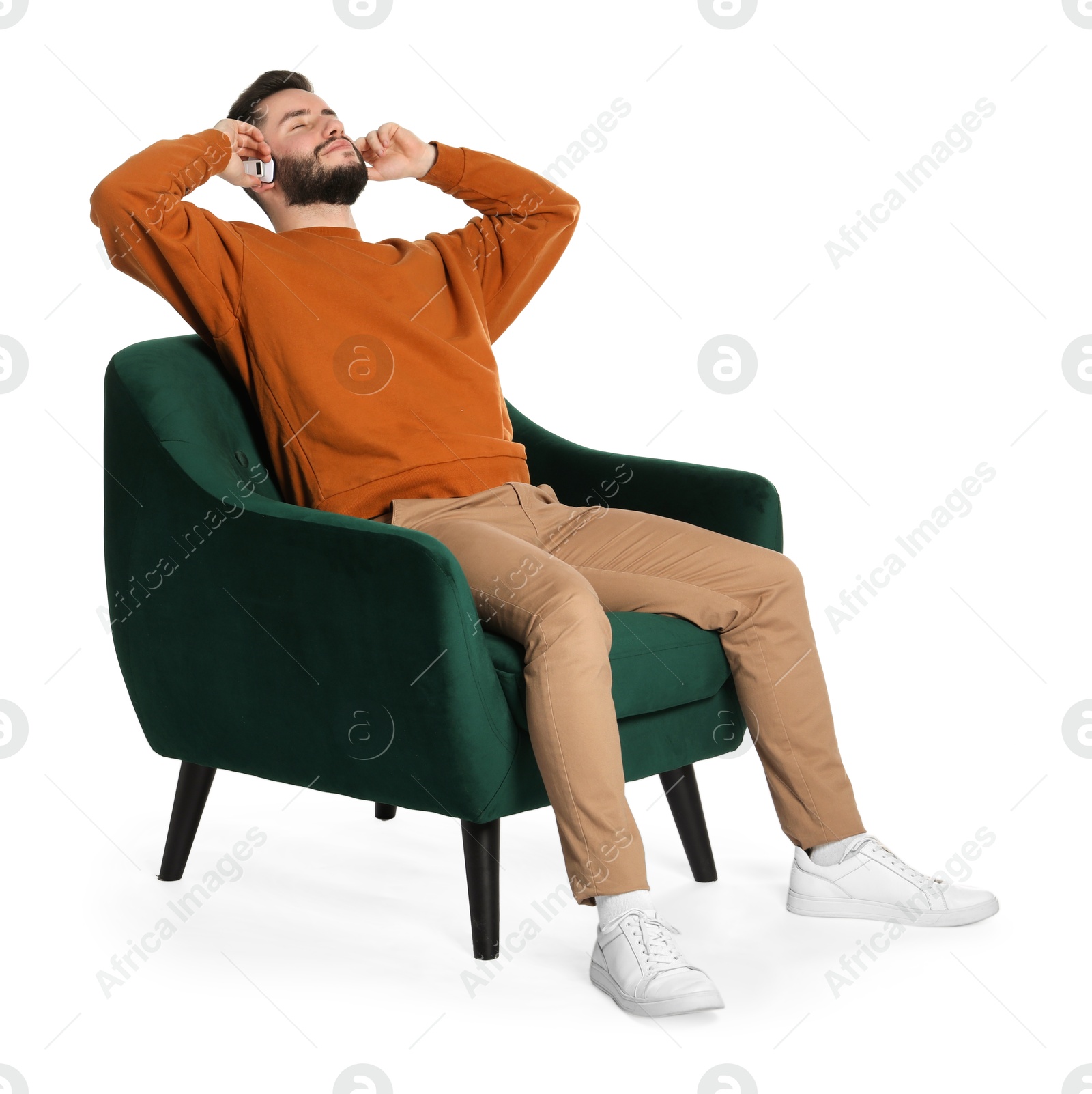 Handsome man in headphones relaxing on armchair against white background Photo of Handsome man in headphones relaxing on armchair against white background