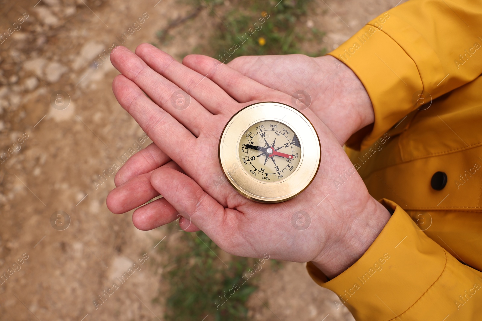 Woman holding compass near pathway outdoors, closeup Photo of Woman holding compass near pathway outdoors, closeup
