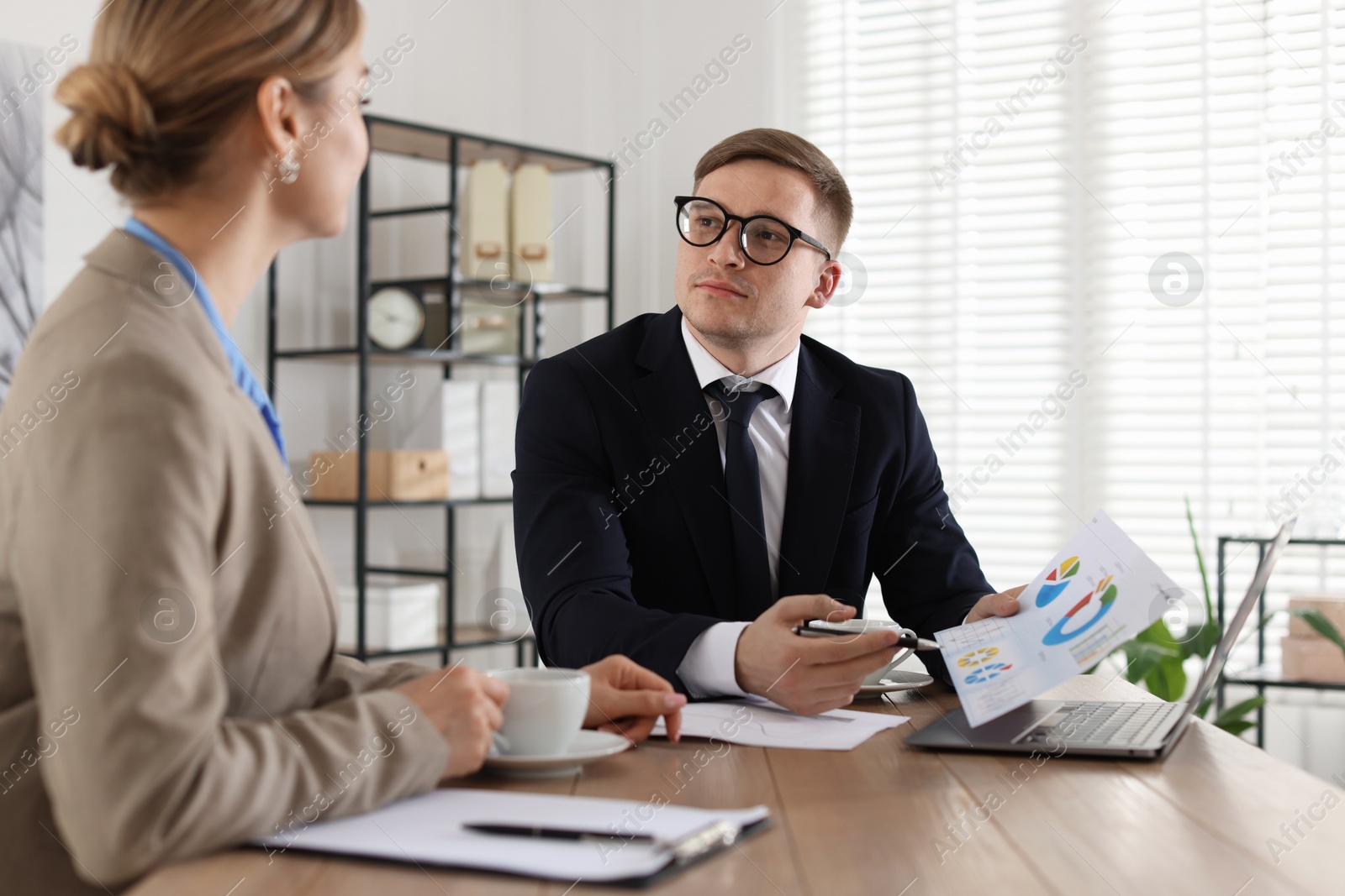 Photo of Woman having meeting with banker at desk in office