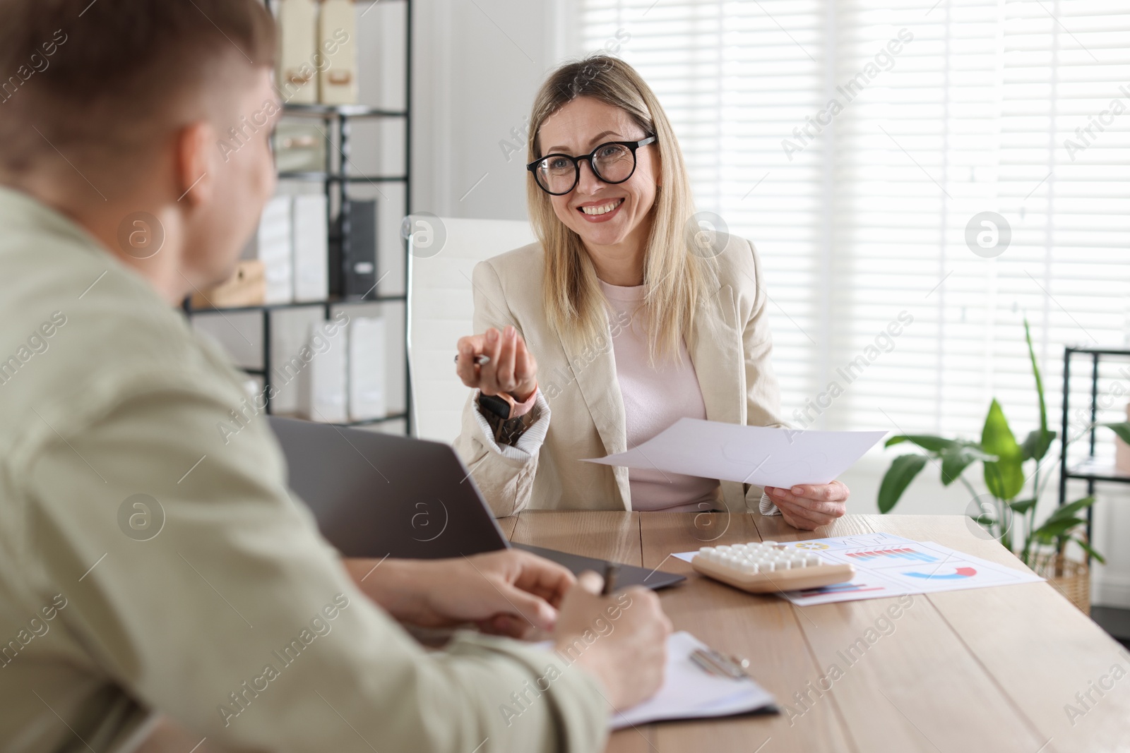 Man having meeting with banker at desk in office Photo of Man having meeting with banker at desk in office