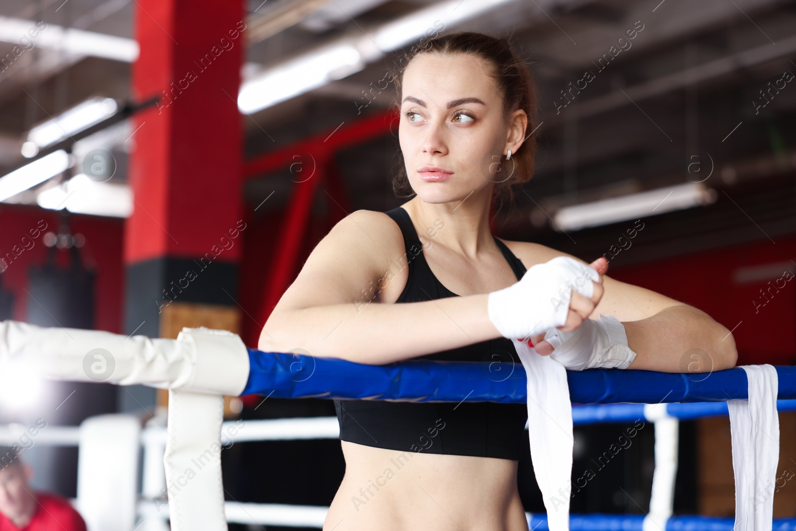Woman wrapping her hands on boxing ring Photo of Woman wrapping her hands on boxing ring