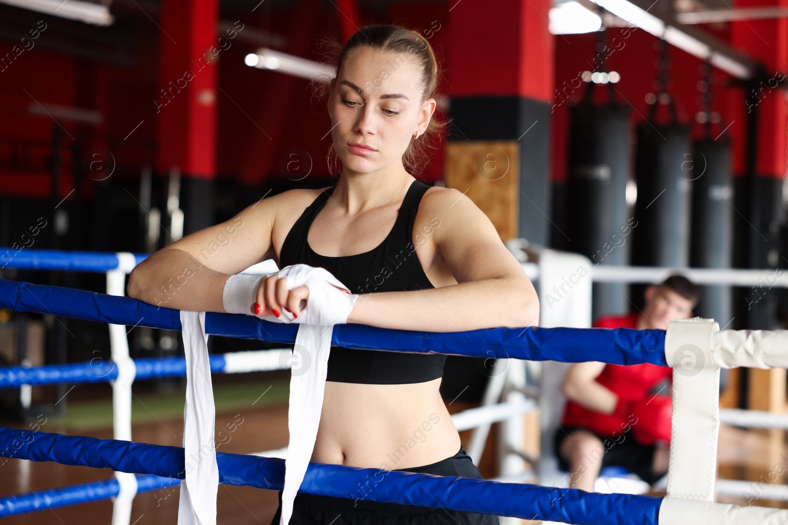 Woman wrapping her hands on boxing ring Photo of Woman wrapping her hands on boxing ring