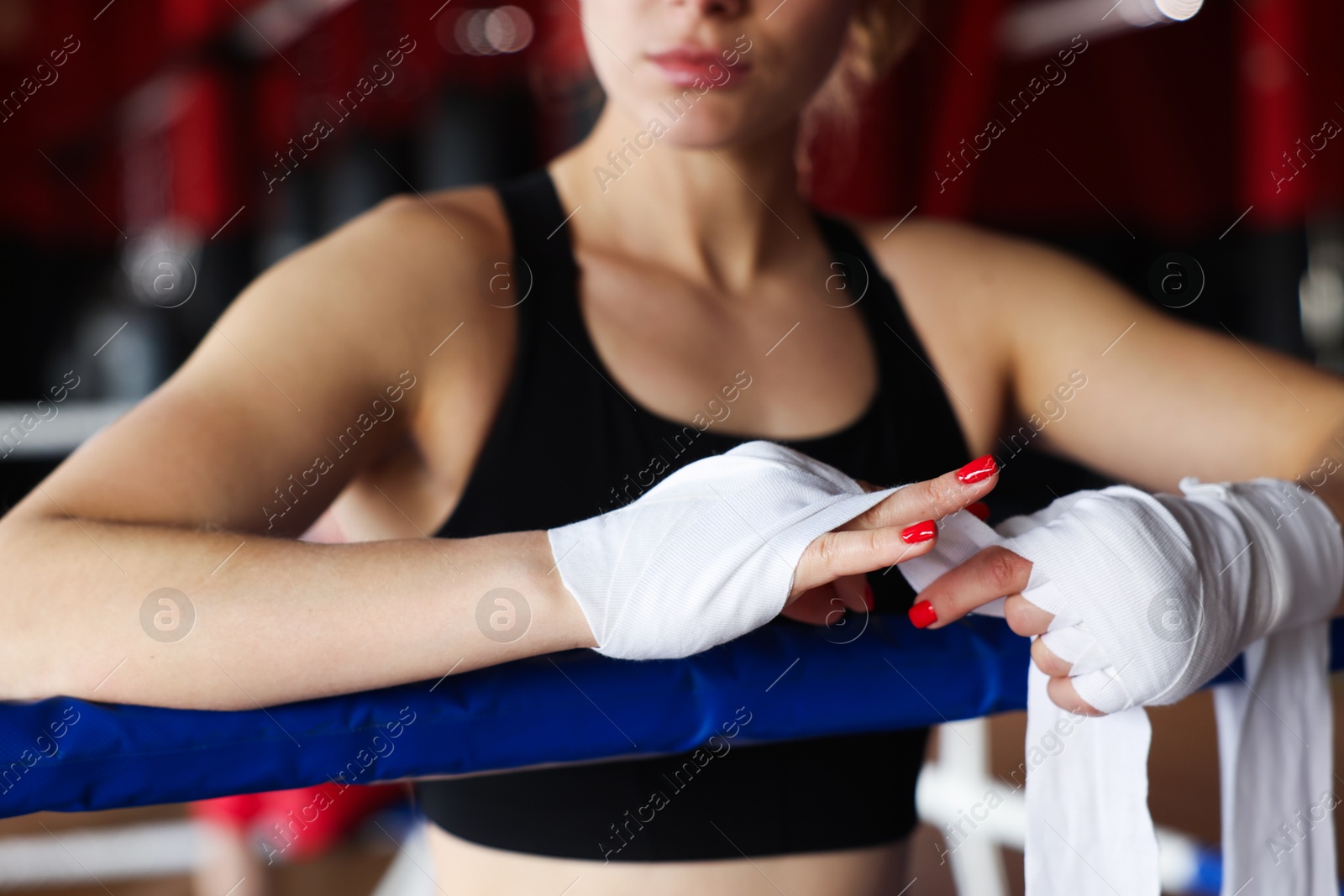 Woman wrapping her hands on boxing ring, closeup Photo of Woman wrapping her hands on boxing ring, closeup