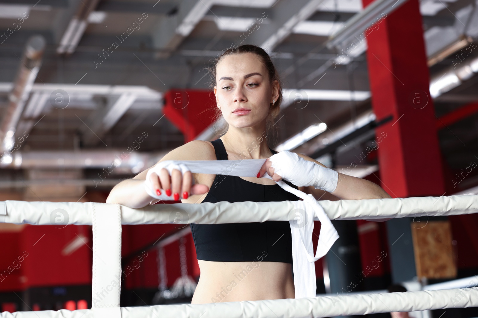 Woman wrapping her hands on boxing ring Photo of Woman wrapping her hands on boxing ring