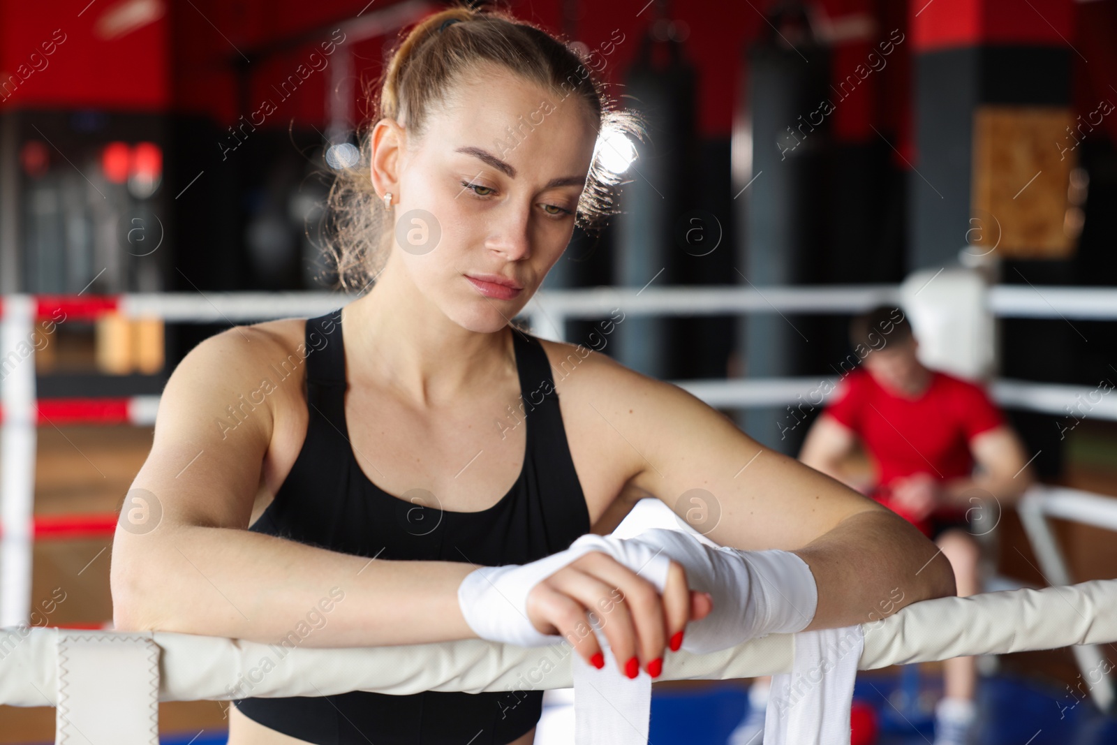 Woman wrapping her hands on boxing ring Photo of Woman wrapping her hands on boxing ring