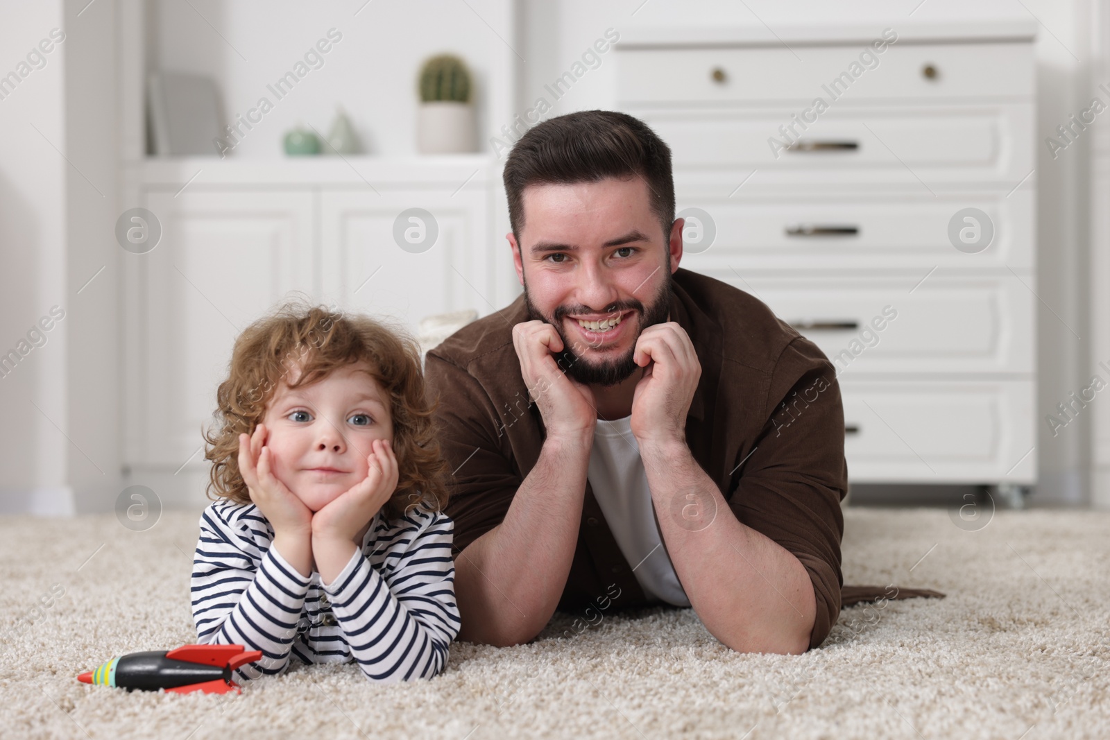 Happy father and his son on floor at home Photo of Happy father and his son on floor at home