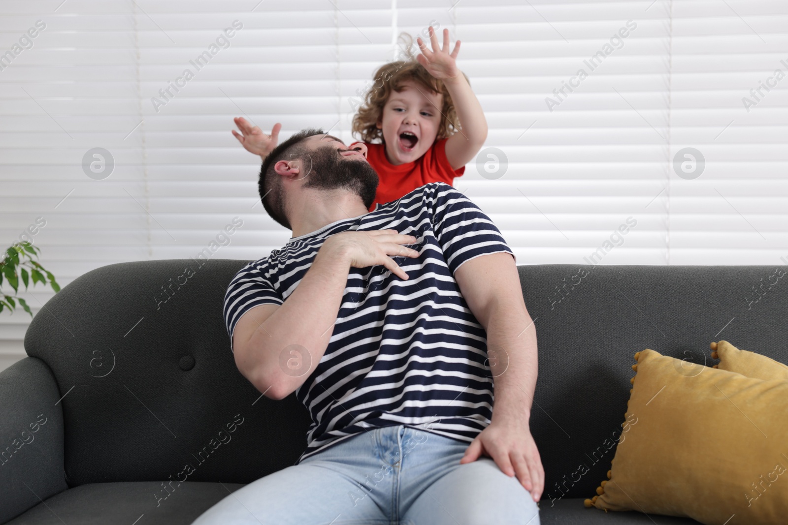 Happy father and his son spending time together on sofa at home Photo of Happy father and his son spending time together on sofa at home