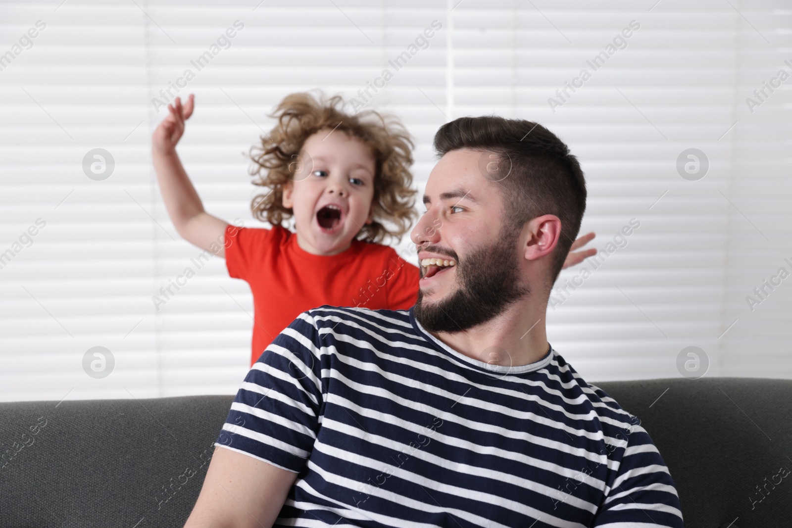 Happy father and his son spending time together on sofa at home Photo of Happy father and his son spending time together on sofa at home