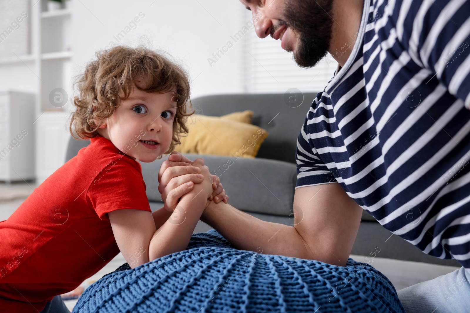 Happy father with his son arm wrestling and spending time together at home, closeup Photo of Happy father with his son arm wrestling and spending time together at home, closeup